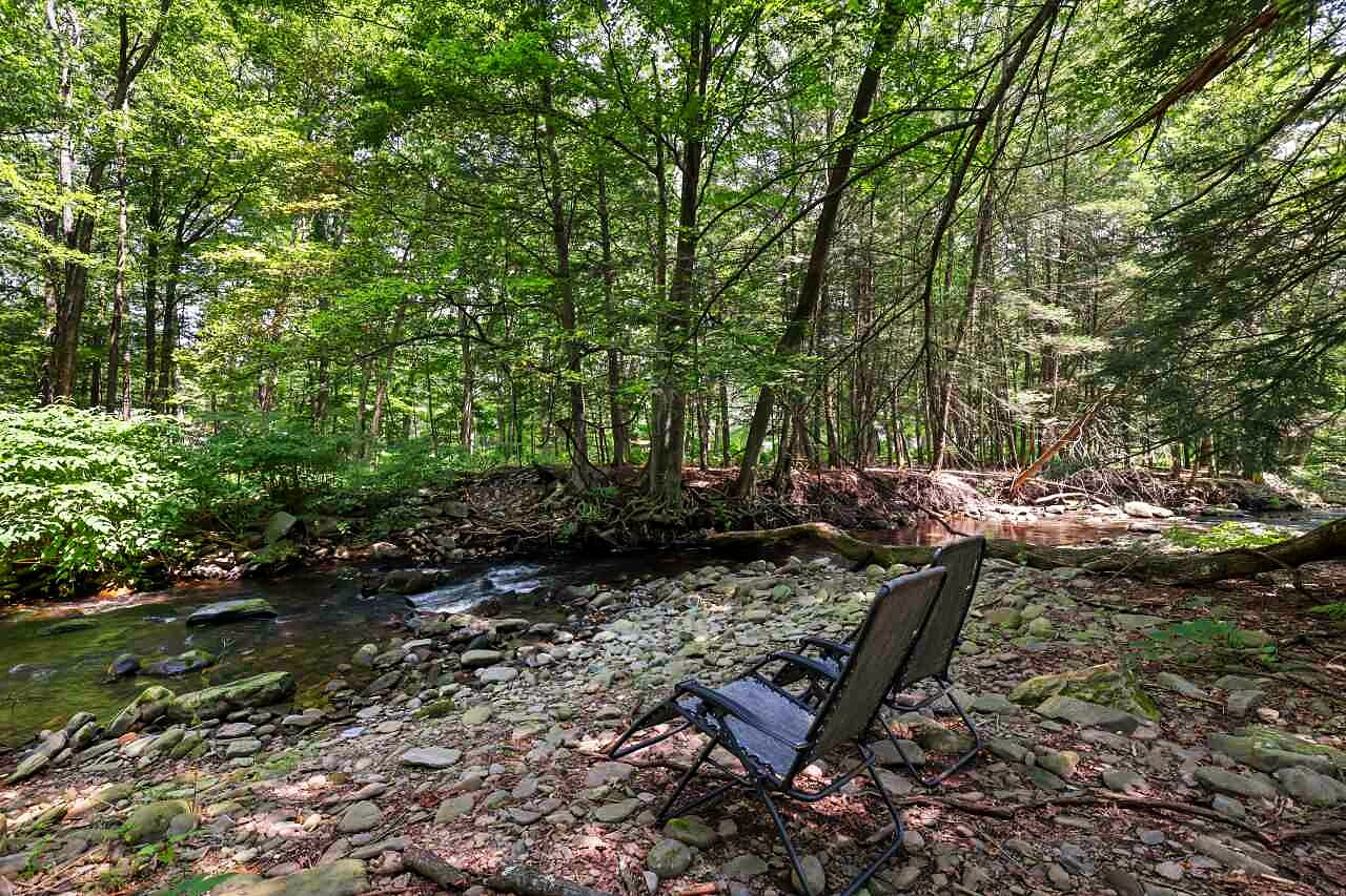 Swiftwater Creek running over rocks, with a single chair at the water.