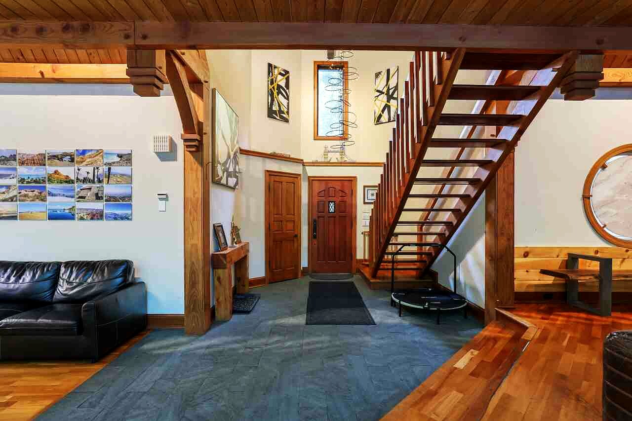 The entry foyer with timber stairs and a stone wall.