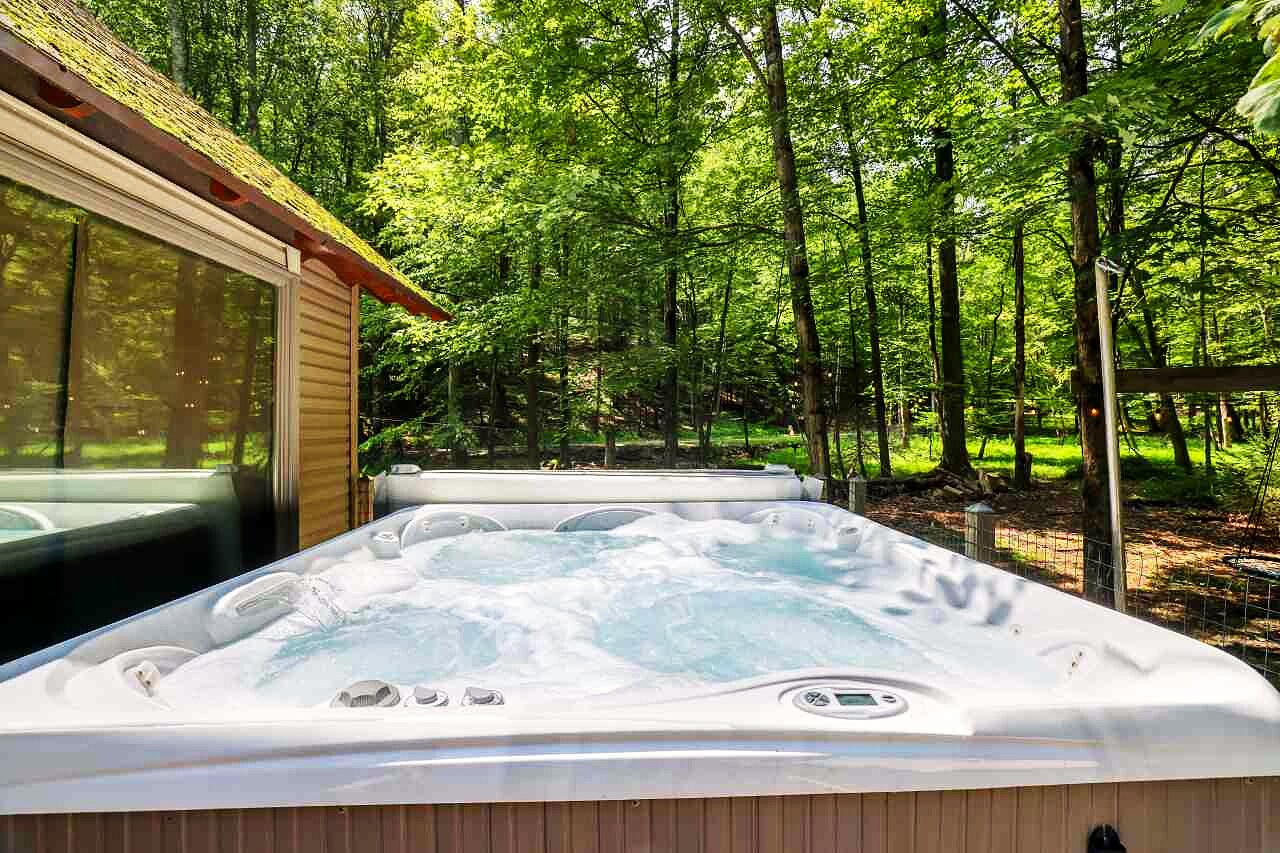 A six-person hot tub set at the edge of the forest.