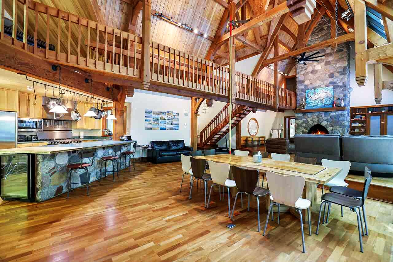 The commercial kitchen with a stone island bar, opening to the great room with the mezzanine above.