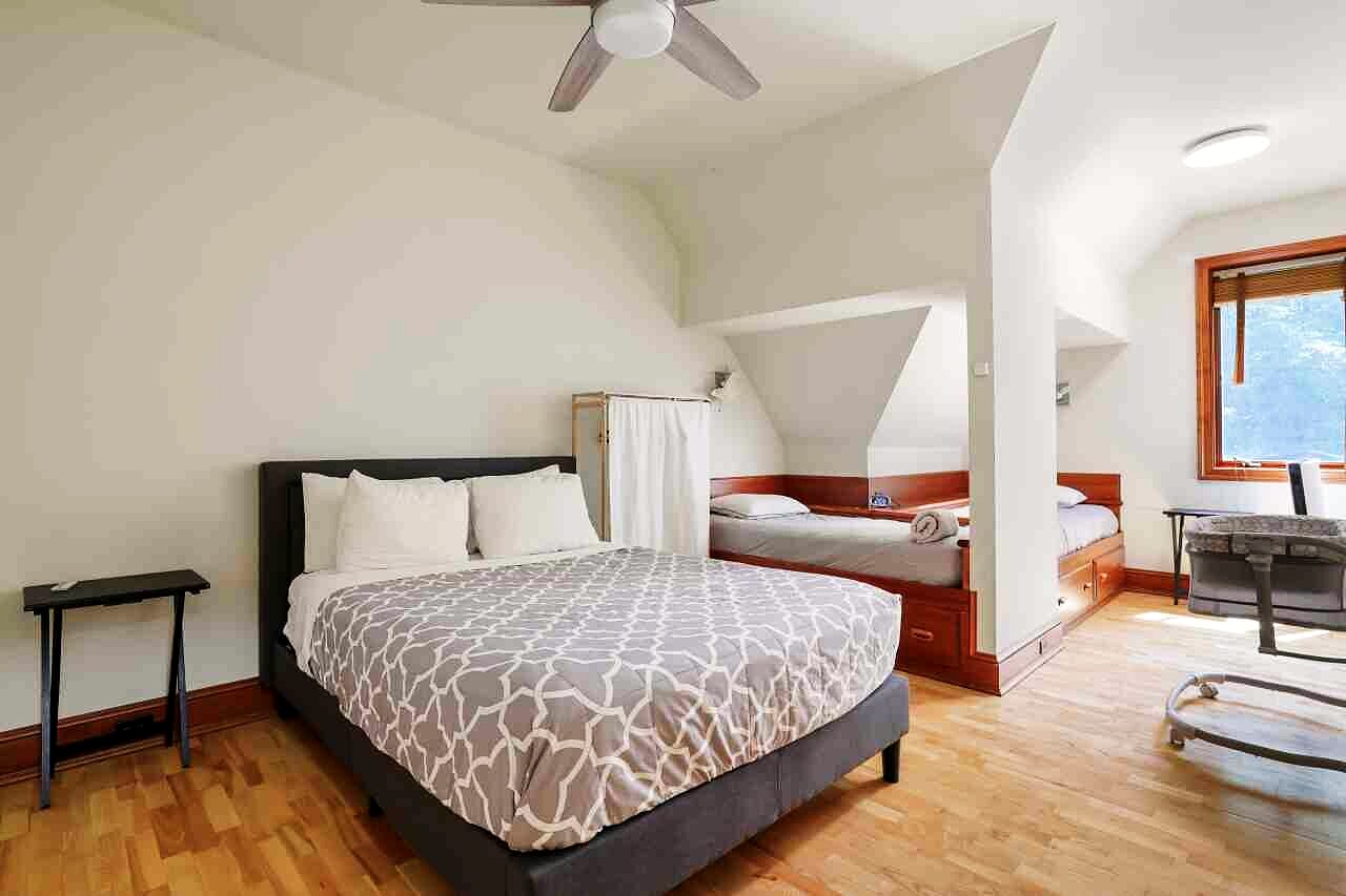A bedroom with a timber ceiling and windows to the trees.